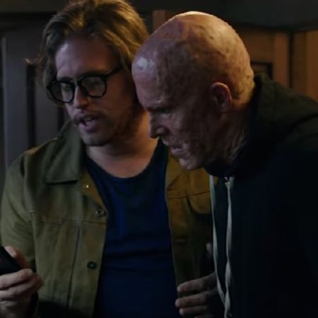 Weasel is looking at his phone as Deadpool looks on.